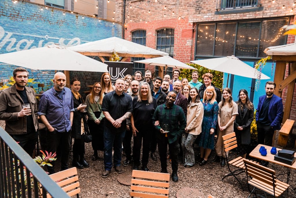 This is an image of a group of people posing for a photograph in the courtyard of a venue. 